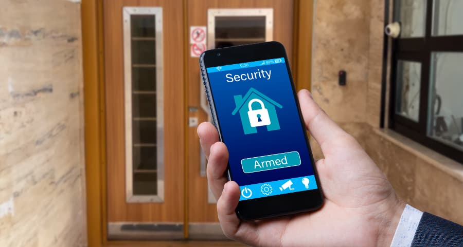 Man using cell phone to arm a home security system